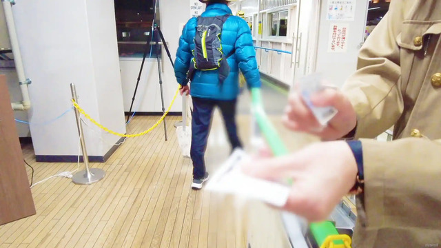 博多ふ頭第二ターミナルの2階乗船口で半券を受け取っている様子