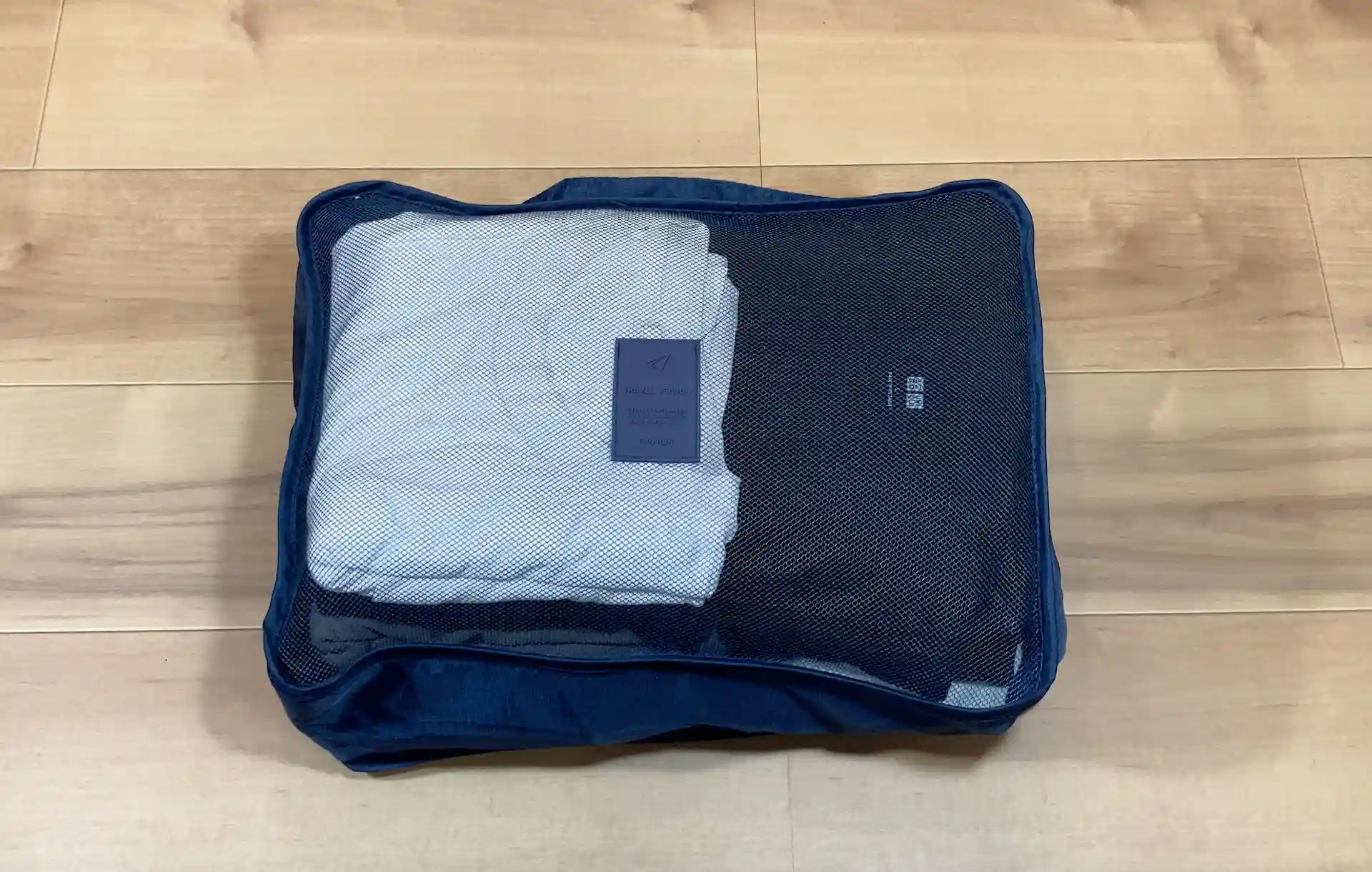 ダイソーのトラベル収納ケースセットに含まれていたLサイズのメッシュケースに衣服を収納した様子
