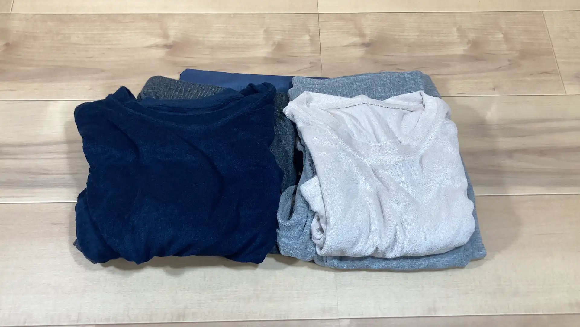 ダイソーのlサイズポーチに収納予定の薄手のパジャマ上下セットが並べられている様子
