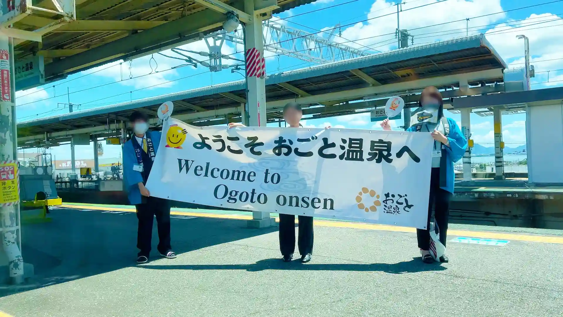 在雄琴溫泉站舉橫幅迎接的場景