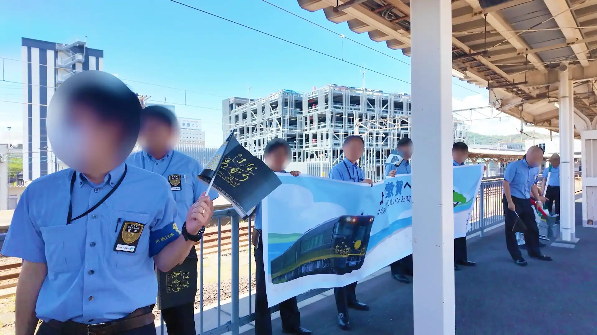 観光列車「はなあかり」の旗を持った敦賀駅の職員