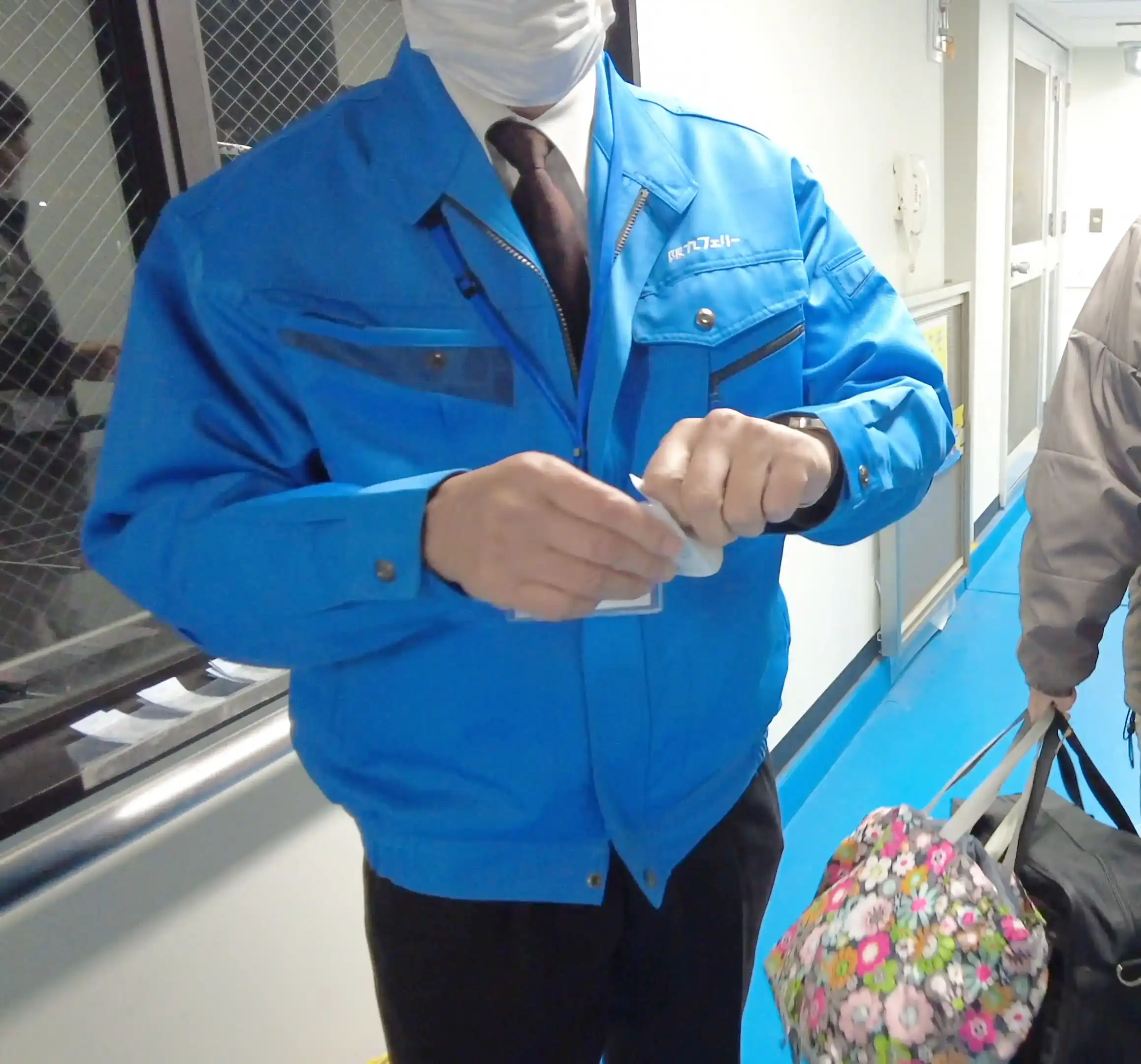 阪九フェリーやまとの乗船前に係員が乗船券をもぎっている様子