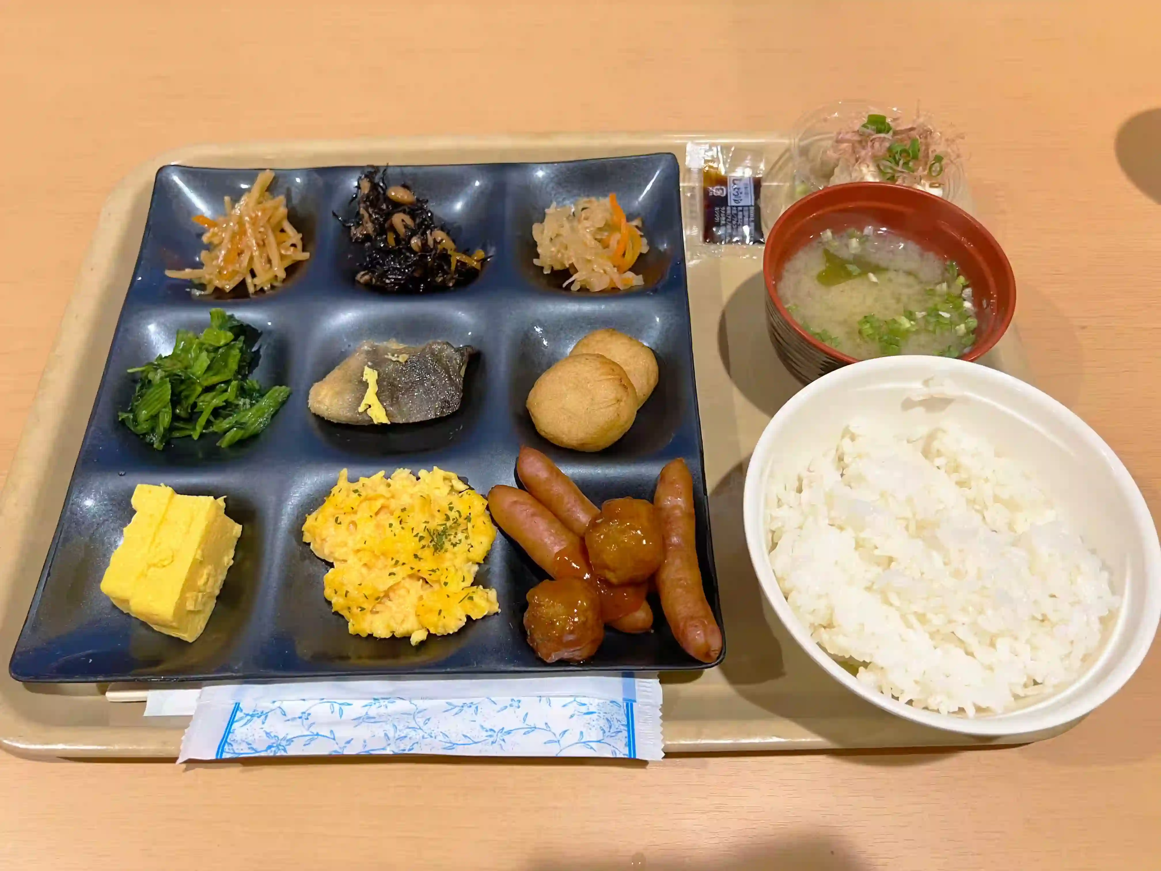 名门大洋渡轮京都的早餐菜品，盘中有肉丸、煮香肠和炒蛋