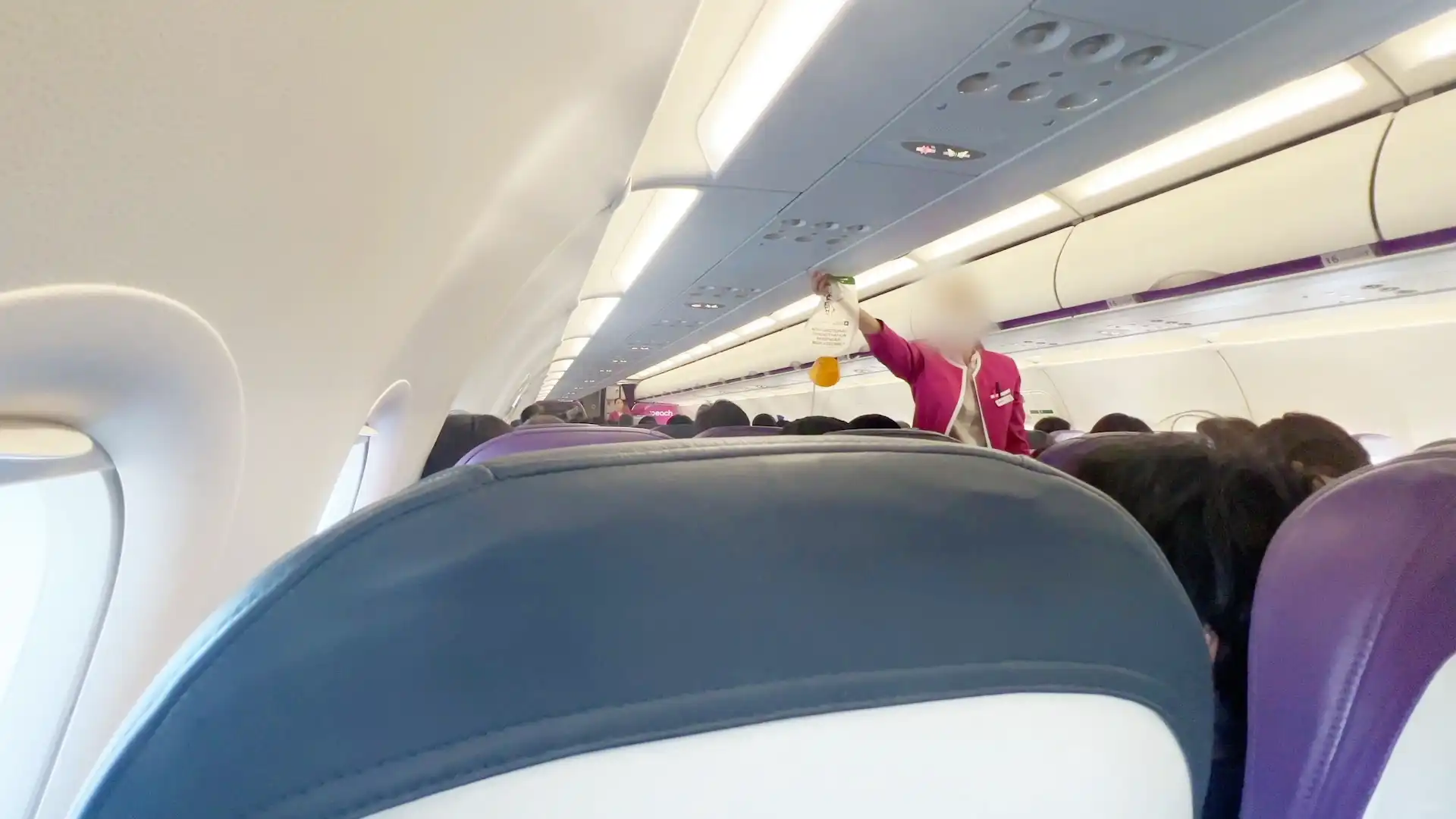 PeachのCAによる酸素マスクの使用方法の解説が行われている様子