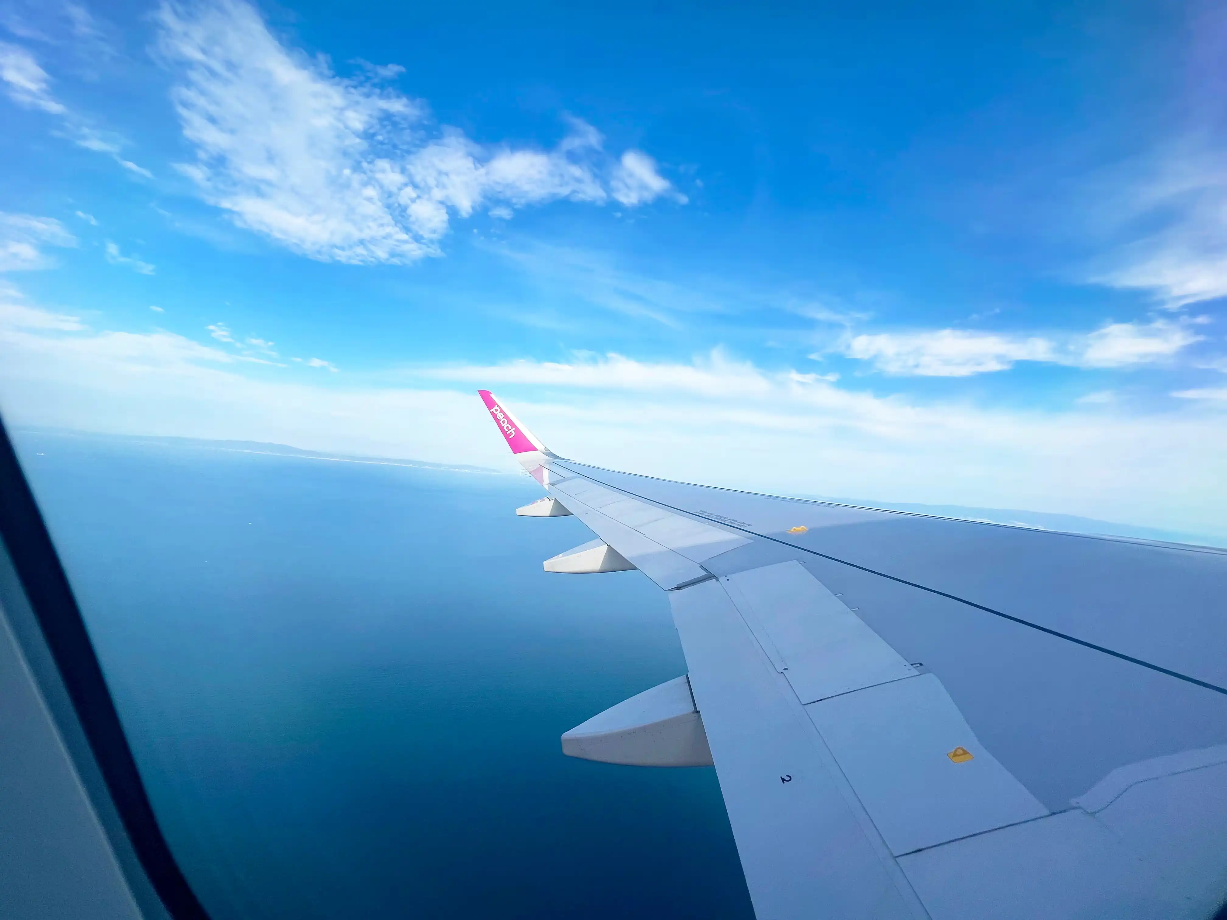 ピーチアビエーション機内の窓側座席から見える上空の景色