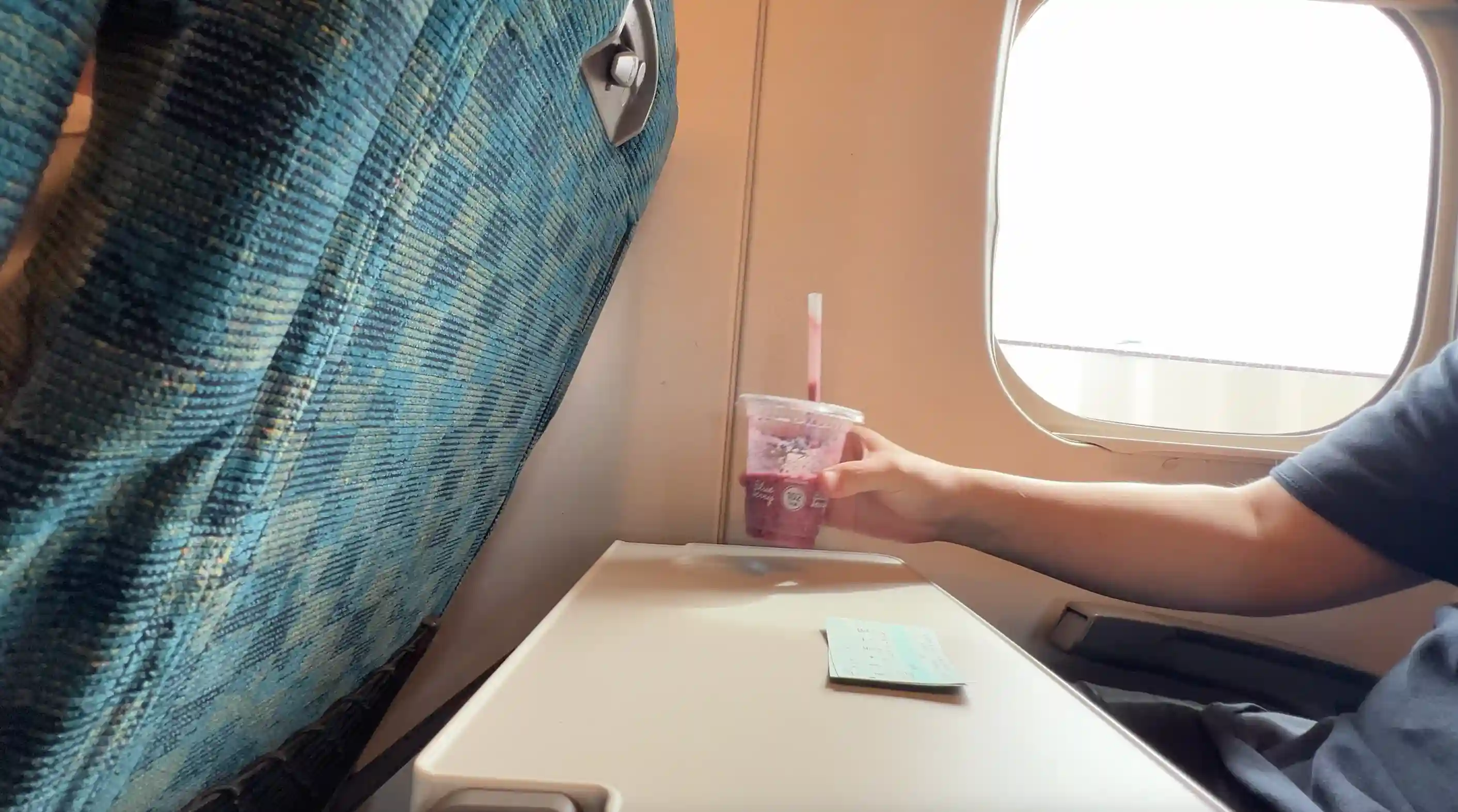 新幹線「さくら」の自由席に座ってスムージーを飲んでいる様子